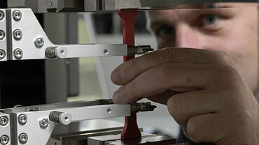Dettaglio  di un provino di trazione con estensimetro nel test sui materiali di stampaggio - proprietà di trazione ASTM D638